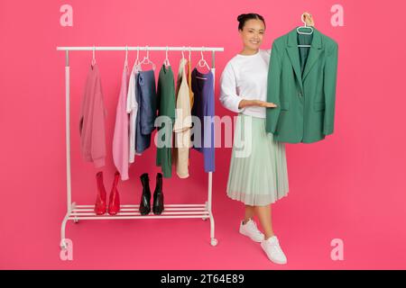 Portrait de jeune femme asiatique souriante présentant New Stylish Clothes Banque D'Images