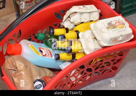 Turin, Piémont, Italie. -08-09-2023 Un panier rouge dans un supermarché avec quelques produits à l'intérieur Banque D'Images