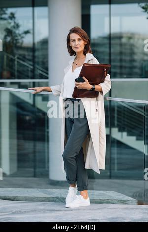 Toute la longueur d'une femme d'affaires d'âge moyen élégant debout à l'extérieur Banque D'Images