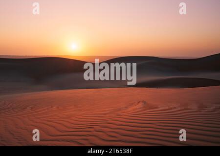 Dunes de sable contre ciel au lever du soleil. Désert de Wahiba Sands dans le Sultanat d'Oman. Banque D'Images
