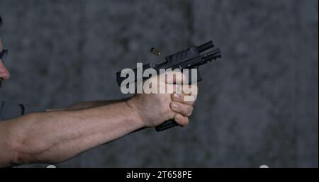 Pistolet gros plan Stoeger STR-9 Striker tiré 9 mm, tir unique au champ de tir en super ralenti 800 images/s. Banque D'Images