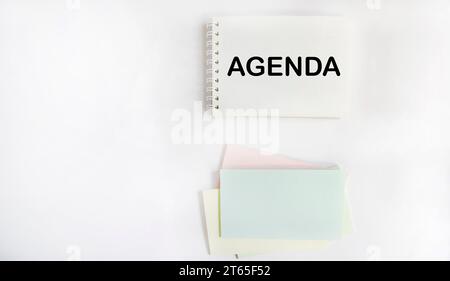 Sur un fond blanc, il y a des autocollants multicolores lumineux et un balcon avec l'AGENDA textuel. Espace de copie Banque D'Images