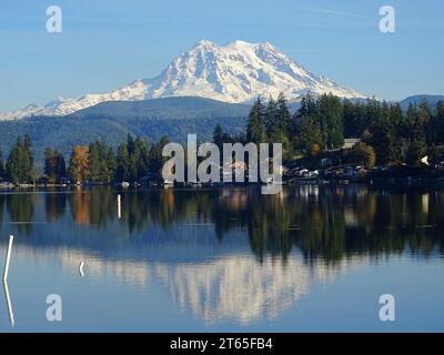 Mont rainier et son reflet dans un lac, ciel bleu clair et couleurs d'automne sur les arbres. État de Washington, États-Unis. Banque D'Images