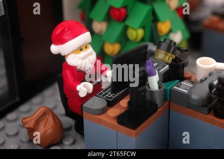 Tambov, Fédération de Russie - 08 novembre 2023 Une minifigurine Lego du Père Noël travaillant sur un ordinateur dans son bureau. Gros plan. Banque D'Images