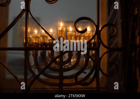 Les bougies de Hanukkah brûlantes jettent une lueur dorée de lumière de feu dans la vieille ville de Jérusalem lors de la huitième nuit de la fête des lumières en Israël. Banque D'Images