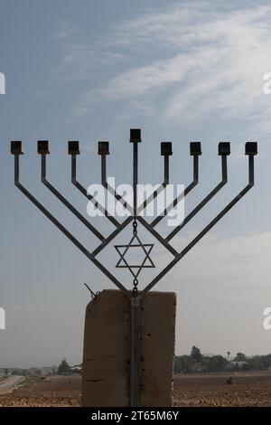 Une grande menorah Hanukkah métallique à huit branches érigée sur une fondation en ciment et placée le long d'une autoroute dans la vallée du Jourdain en Israël. Banque D'Images