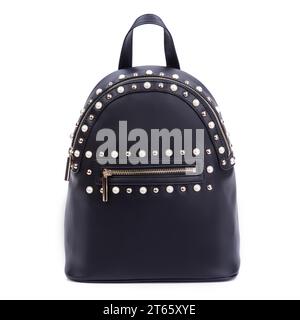 Élégant sac à dos pour femme en cuir noir avec une fermeture éclair décorée de rivets en métal doré et perle isolés sur un fond blanc. Gros plan. Mode blogg Banque D'Images