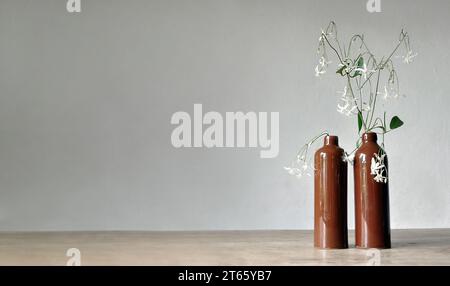 Composition artistique minimaliste. Fragments d'une ancienne maison de campagne à l'intérieur - murs éclairés plâtrés, une ancienne table en bois, bouteilles vitrées en argile Banque D'Images