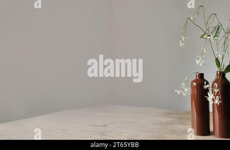 Composition artistique minimaliste. Fragments d'une ancienne maison de campagne à l'intérieur - murs éclairés plâtrés, une ancienne table en bois, bouteilles vitrées en argile Banque D'Images