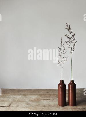 Composition artistique minimaliste. Fragments d'une ancienne maison de campagne à l'intérieur - murs éclairés plâtrés, une ancienne table en bois, bouteilles vitrées en argile Banque D'Images