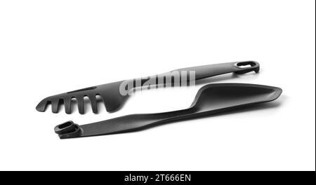 Pinces de cuisine noires démontables avec support éco-plastique. Ustensiles de cuisine pratiques pour préparer et servir des plats. Articles ménagers ergonomiques fabriqués Banque D'Images