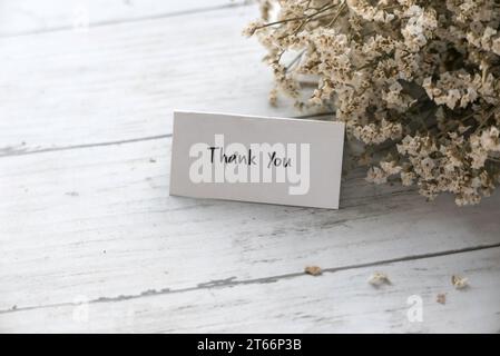 Merci note avec un bouquet de fleurs. Banque D'Images