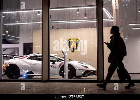 Moscou, Russie. 08 novembre 2023. Une jeune femme passe devant la fenêtre d'un concessionnaire automobile Lamborghini à Moscou. (Photo Alexander Sayganov/SOPA Images/Sipa USA) crédit : SIPA USA/Alamy Live News Banque D'Images