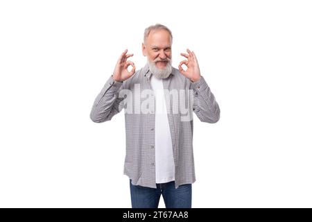 mignon charmant grand-père intelligent avec une barbe blanche et une moustache est habillé d'une chemise rayée et un jean Banque D'Images