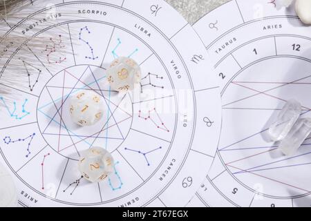 Roue du zodiaque, carte natale, dés d'astrologie et pierres sur table grise, mise à plat Banque D'Images