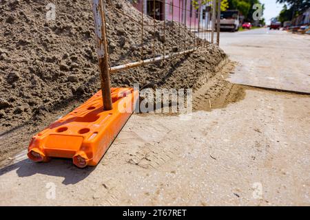 Le pied creux de clôture en plastique est pour la stabilité des panneaux temporaires de clôture en fil métallique, installés devant le chantier à côté de la rue. Banque D'Images