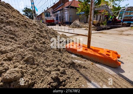 Le pied creux de clôture en plastique est pour la stabilité des panneaux temporaires de clôture en fil métallique, installés devant le chantier à côté de la rue. Banque D'Images