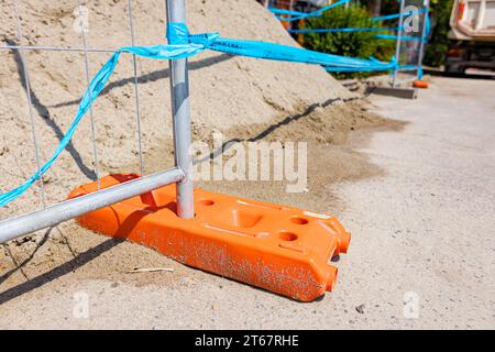 Le pied creux de clôture en plastique est pour la stabilité des panneaux temporaires de clôture en fil métallique, installés devant le chantier à côté de la rue. Banque D'Images