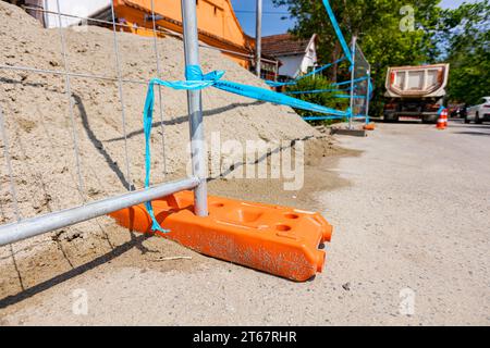 Le pied creux de clôture en plastique est pour la stabilité des panneaux temporaires de clôture en fil métallique, installés devant le chantier à côté de la rue. Banque D'Images