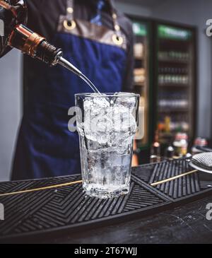 Barman professionnel préparer un cocktail frais dans le verre avec une glace au bar Banque D'Images