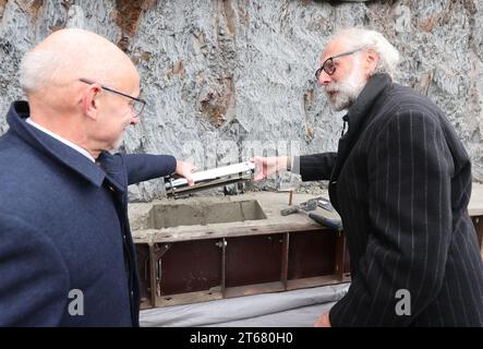 Posterstein, Allemagne. 09 novembre 2023. Uwe Melzer (à gauche, CDU), administrateur de district d'Altenburger Land, et Klaus Hofmann, directeur du château, tiennent un cercueil de pierre de fondation lors de la pose de la pierre de fondation pour la reconstruction de l'aile nord du château de Posterstein. Le coût total s'élève à quatre millions d'euros. Crédit : Bodo Schackow/dpa/Alamy Live News Banque D'Images