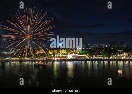 Vue aérienne des feux d'artifice explosant au-dessus de la rivière Tonle SAP, des péniches illuminées et du Palais Royal pour célébrer le Festival de l'eau Khmer, Phnom Penh, Cambodge Banque D'Images