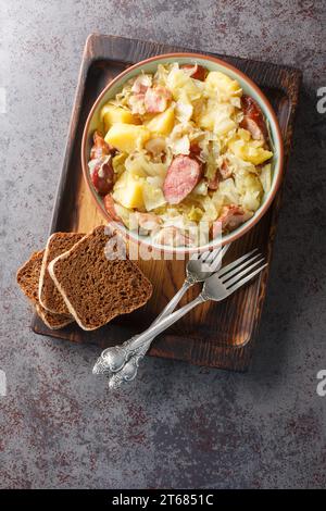 Allemand Jager Kohl, chou de chasseur avec saucisse, bacon et pommes de terre gros plan dans un bol sur la table. Vue verticale de dessus Banque D'Images