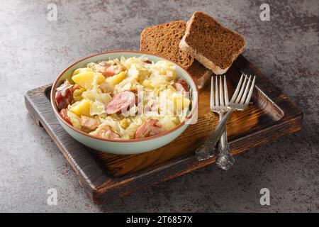 Ragoût de chou de chasseur allemand avec pommes de terre, saucisse, bacon et oignons gros plan dans un bol sur la table. Gros plan horizontal dans un bol sur la table. Horiz Banque D'Images