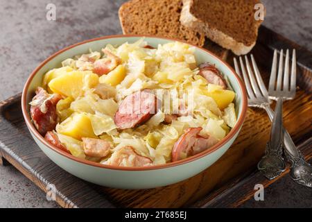 Chou de Hunter cuit avec saucisse, pommes de terre, bacon et oignons en gros plan dans un bol sur la table. Horizontal Banque D'Images