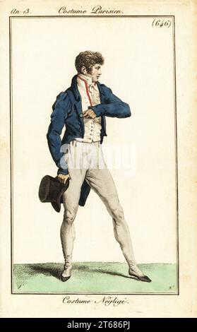 Dandy français en tenue décontractée, Paris, 1805. Il porte un blouson, un gilet double, une cravate, des pantalons, des pantoufles et tient un chapeau haut de gamme. Déguisement négligé. Carle Vernet et Bacquoy. Gravure sur cuivre coloriée à la main par Pierre-Charles Baquoy d'après Carle Vernet de Pierre de la Mesangeres Journal des Dames et des modes, Magazine des femmes et de la mode, Paris, an 13, 1805. Banque D'Images