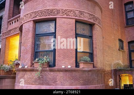 Une variété de plantes en pot sont exposées dans les boîtes de fenêtre d'une maison, ajoutant une touche de verdure à l'avant du bâtiment Banque D'Images