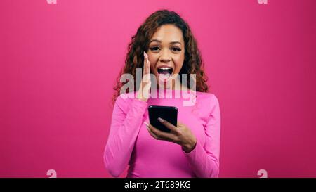 Choqué jeune femme obtient un match réussi sur le profil datant, studio rose Banque D'Images