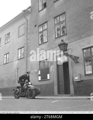 Police sur une moto en 1941. Un policier sur une moto avec un side-car devant le poste de police du 7e arrondissement de Östermalm à Stockholm. Le gendarme a reçu une alarme au sujet d'un cambriolage en cours et part avec la moto. Suède 1941. Kristoffersson ref 218-18 Banque D'Images