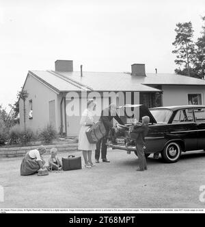 Conduire dans les années 1960 Une famille avec leur voiture, une Opel Rekord, et le couple sont vus mettre leurs bagages et valises dans le coffre. Suède 1961 Kristoffersson Réf CU75-3 Banque D'Images