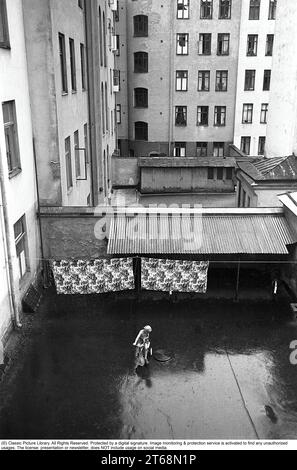 Stockholm dans les années 1950 Un enfant monte un tricycle dans une cour arrière dans le centre de Stockholm. À l'intérieur des immeubles d'appartements sont souvent des zones ouvertes où les résidents pourraient accrocher le linge, garer des vélos, etc De l'arrière-cour il y avait aussi des entrées aux toilettes, buanderie, salle des ordures, etc Cependant, un endroit calme et paisible où vous semblez être autorisé à jouer en paix. Stockholm Suède 1954. Kristoffersson réf. 2a-25 Banque D'Images