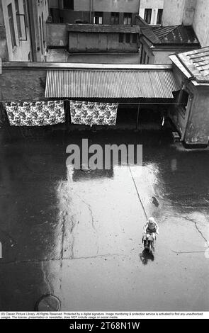 Stockholm dans les années 1950 Un enfant monte un tricycle dans une cour arrière dans le centre de Stockholm. À l'intérieur des immeubles d'appartements sont souvent des zones ouvertes où les résidents pourraient accrocher le linge, garer des vélos, etc De l'arrière-cour il y avait aussi des entrées aux toilettes, buanderie, salle des ordures, etc Cependant, un endroit calme et paisible où vous semblez être autorisé à jouer en paix. Stockholm Suède 1954. Kristoffersson réf. 2a-25 Banque D'Images