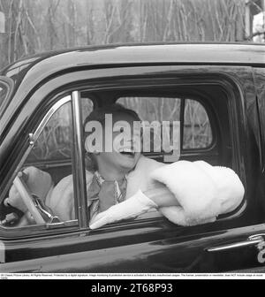 Dans les années 1950 L'actrice Sonja Wigert, 1913-1980 ans photographiée dans sa voiture 1954 où elle est vue souriante joyeusement, élégamment habillée avec un bras sur la vitre rabattue. Suède 1954. Kristoffersson réf BP8-12 Banque D'Images