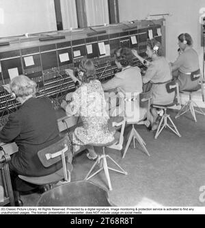 La téléphonie dans les années 1940 Les femmes travaillant à un standard téléphonique comme opérateurs. Un système de communication téléphonique qui était actionné manuellement où les appels entrants étaient renvoyés et réacheminés vers un autre numéro de téléphone par l'opérateur, en l'occurrence localement dans l'immeuble desservant une entreprise ou une organisation disposant de nombreuses lignes téléphoniques internes. L'opérateur du standard téléphonique pouvait prendre des messages, vous mettre en attente si la ligne était occupée. Suède 1945 Banque D'Images