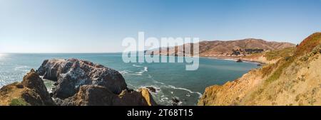 Une vue aérienne époustouflante d'un paysage marin avec un rivage rocheux et un soleil éclatant descendant sur les rochers et l'eau environnante Banque D'Images