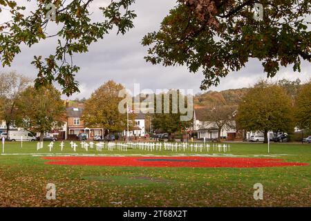 Wooburn Green, Royaume-Uni. 9 novembre 2023. Un magnifique énorme cypher de coquelicot a été peint sur le vert du village à Wooburn Green, Buckinghamshire avant le jour de l'Armistice et le dimanche du souvenir ce week-end avec les mots Wooburn Green We Will Remember. Prenant trois heures pour terminer, le coquelicot de 10 pieds a été conçu et peint par le gardien de sol local et gestionnaire des contrats à Groundtel, Danny Perkins. Les 1st Wooburn Scouts ont également placé 146 croix commémoratives à côté du coquelicot en mémoire des villageois morts pendant la première et la Seconde Guerre mondiale. Crédit : Maureen McLean/Alamy Live News Banque D'Images