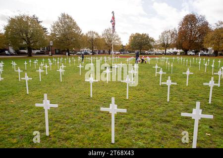 Wooburn Green, Royaume-Uni. 9 novembre 2023. Un magnifique énorme cypher de coquelicot a été peint sur le vert du village à Wooburn Green, Buckinghamshire avant le jour de l'Armistice et le dimanche du souvenir ce week-end avec les mots Wooburn Green We Will Remember. Prenant trois heures pour terminer, le coquelicot de 10 pieds a été conçu et peint par le gardien de sol local et gestionnaire des contrats à Groundtel, Danny Perkins. Les 1st Wooburn Scouts ont également placé 146 croix commémoratives à côté du coquelicot en mémoire des villageois morts pendant la première et la Seconde Guerre mondiale. Crédit : Maureen McLean/Alamy Live News Banque D'Images