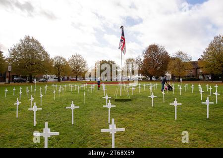 Wooburn Green, Royaume-Uni. 9 novembre 2023. Un magnifique énorme cypher de coquelicot a été peint sur le vert du village à Wooburn Green, Buckinghamshire avant le jour de l'Armistice et le dimanche du souvenir ce week-end avec les mots Wooburn Green We Will Remember. Prenant trois heures pour terminer, le coquelicot de 10 pieds a été conçu et peint par le gardien de sol local et gestionnaire des contrats à Groundtel, Danny Perkins. Les 1st Wooburn Scouts ont également placé 146 croix commémoratives à côté du coquelicot en mémoire des villageois morts pendant la première et la Seconde Guerre mondiale. Crédit : Maureen McLean/Alamy Live News Banque D'Images