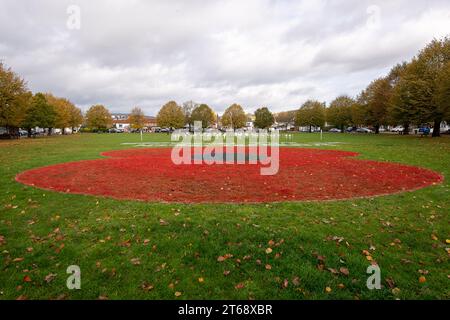 Wooburn Green, Royaume-Uni. 9 novembre 2023. Un magnifique énorme cypher de coquelicot a été peint sur le vert du village à Wooburn Green, Buckinghamshire avant le jour de l'Armistice et le dimanche du souvenir ce week-end avec les mots Wooburn Green We Will Remember. Prenant trois heures pour terminer, le coquelicot de 10 pieds a été conçu et peint par le gardien de sol local et gestionnaire des contrats à Groundtel, Danny Perkins. Les 1st Wooburn Scouts ont également placé 146 croix commémoratives à côté du coquelicot en mémoire des villageois morts pendant la première et la Seconde Guerre mondiale. Crédit : Maureen McLean/Alamy Live News Banque D'Images