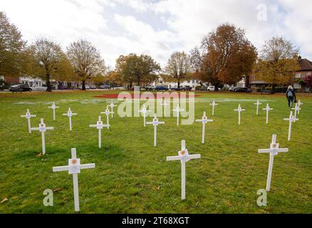 Wooburn Green, Royaume-Uni. 9 novembre 2023. Un magnifique énorme cypher de coquelicot a été peint sur le vert du village à Wooburn Green, Buckinghamshire avant le jour de l'Armistice et le dimanche du souvenir ce week-end avec les mots Wooburn Green We Will Remember. Prenant trois heures pour terminer, le coquelicot de 10 pieds a été conçu et peint par le gardien de sol local et gestionnaire des contrats à Groundtel, Danny Perkins. Les 1st Wooburn Scouts ont également placé 146 croix commémoratives à côté du coquelicot en mémoire des villageois morts pendant la première et la Seconde Guerre mondiale. Crédit : Maureen McLean/Alamy Live News Banque D'Images