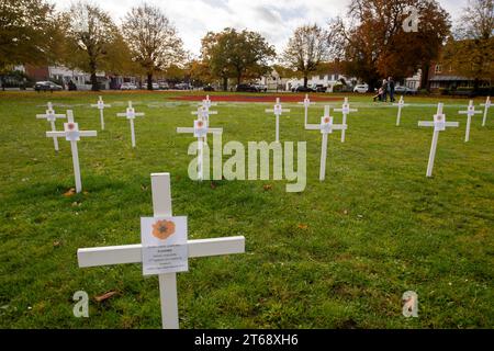 Wooburn Green, Royaume-Uni. 9 novembre 2023. Un magnifique énorme cypher de coquelicot a été peint sur le vert du village à Wooburn Green, Buckinghamshire avant le jour de l'Armistice et le dimanche du souvenir ce week-end avec les mots Wooburn Green We Will Remember. Prenant trois heures pour terminer, le coquelicot de 10 pieds a été conçu et peint par le gardien de sol local et gestionnaire des contrats à Groundtel, Danny Perkins. Les 1st Wooburn Scouts ont également placé 146 croix commémoratives à côté du coquelicot en mémoire des villageois morts pendant la première et la Seconde Guerre mondiale. Crédit : Maureen McLean/Alamy Live News Banque D'Images