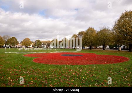 Wooburn Green, Royaume-Uni. 9 novembre 2023. Un magnifique énorme cypher de coquelicot a été peint sur le vert du village à Wooburn Green, Buckinghamshire avant le jour de l'Armistice et le dimanche du souvenir ce week-end avec les mots Wooburn Green We Will Remember. Prenant trois heures pour terminer, le coquelicot de 10 pieds a été conçu et peint par le gardien de sol local et gestionnaire des contrats à Groundtel, Danny Perkins. Les 1st Wooburn Scouts ont également placé 146 croix commémoratives à côté du coquelicot en mémoire des villageois morts pendant la première et la Seconde Guerre mondiale. Crédit : Maureen McLean/Alamy Live News Banque D'Images