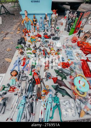 Une table en bois remplie d'un assortiment de figurines jouets colorées et un camion jouet garé à côté Banque D'Images