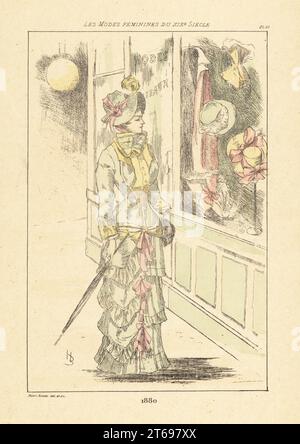 Une femme à la mode qui fait du lèche-vitrine à l'extérieur d'une boutique de vêtements et de chapeaux, Paris, 1880. Gravure en pointe-seche ou à pointe-séche de couleur main par Henri Boutet des modes Feminines du XIXème siècle Siecle (Fashions féminines du 19th siècle), Ernest Flammarion, Paris, 1902. Boutet (1851-1919) est un artiste, graveur, lithographe et designer français. Banque D'Images