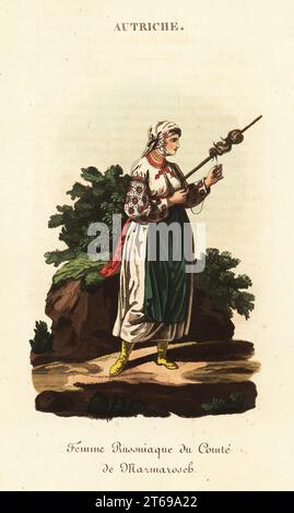 Serf russe filant la laine, comté de Mararmoros, Royaume de Hongrie, 18e siècle. Elle porte des vêtements faits maison et cousus maison de shift blanc brodé avec des manches en dentelle, un mouchoir en lin sur la tête, un tablier vert. Elle tourne de la laine sur un distaff. Femme paysanne russniaque du Palatinat de Marmoros, Femme russe du comte de Marmarosch. Gravure sur cuivre coloriée à la main d'après une illustration de William Alexander de J-B. Eyries l'Autriche : costumes, Moeurs et usages des autrichiens, Austria : costumes, Manners and Mores of the Austrians, Librairie de Gide fils, Paris, 1823. Jean-Baptiste Eyri Banque D'Images