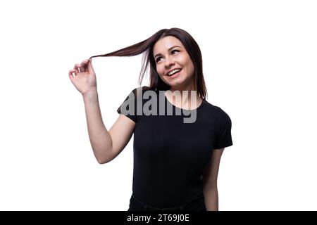 Jeune femme brune élancée aux cheveux courts et droits portant un T-shirt noir Banque D'Images